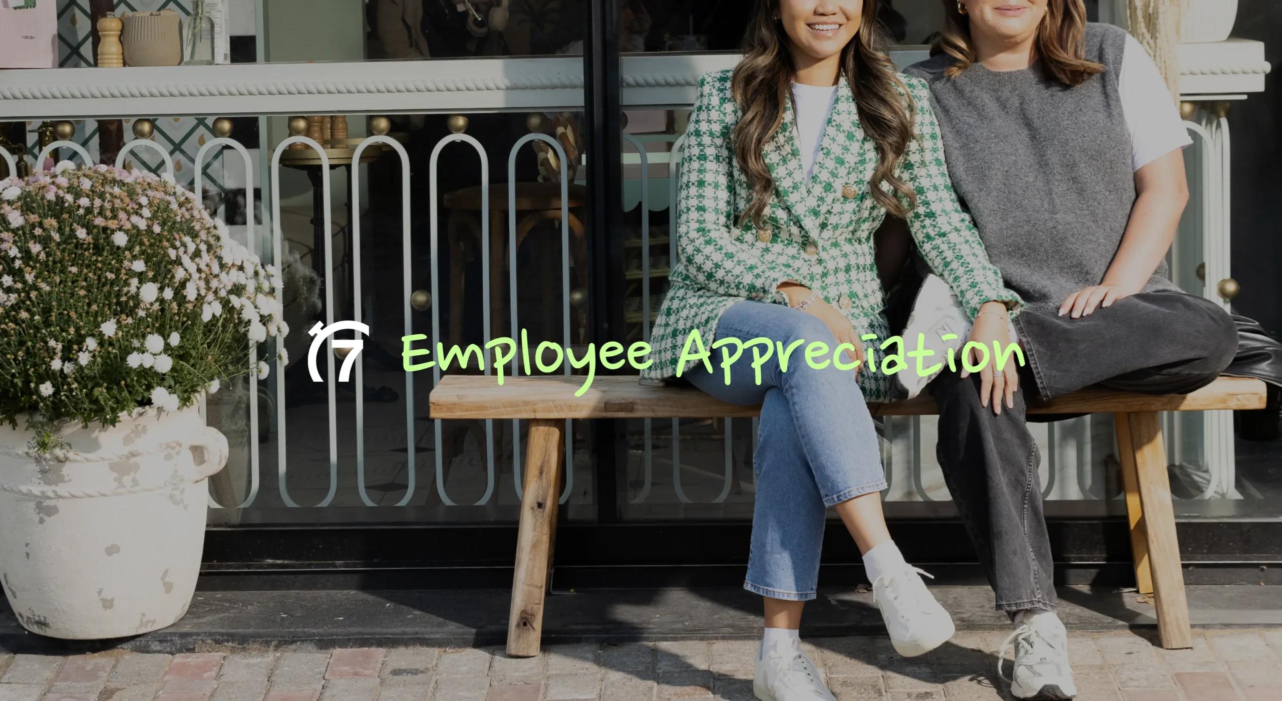 Image of 2 restaurant worker women sitting on bench outside storefront