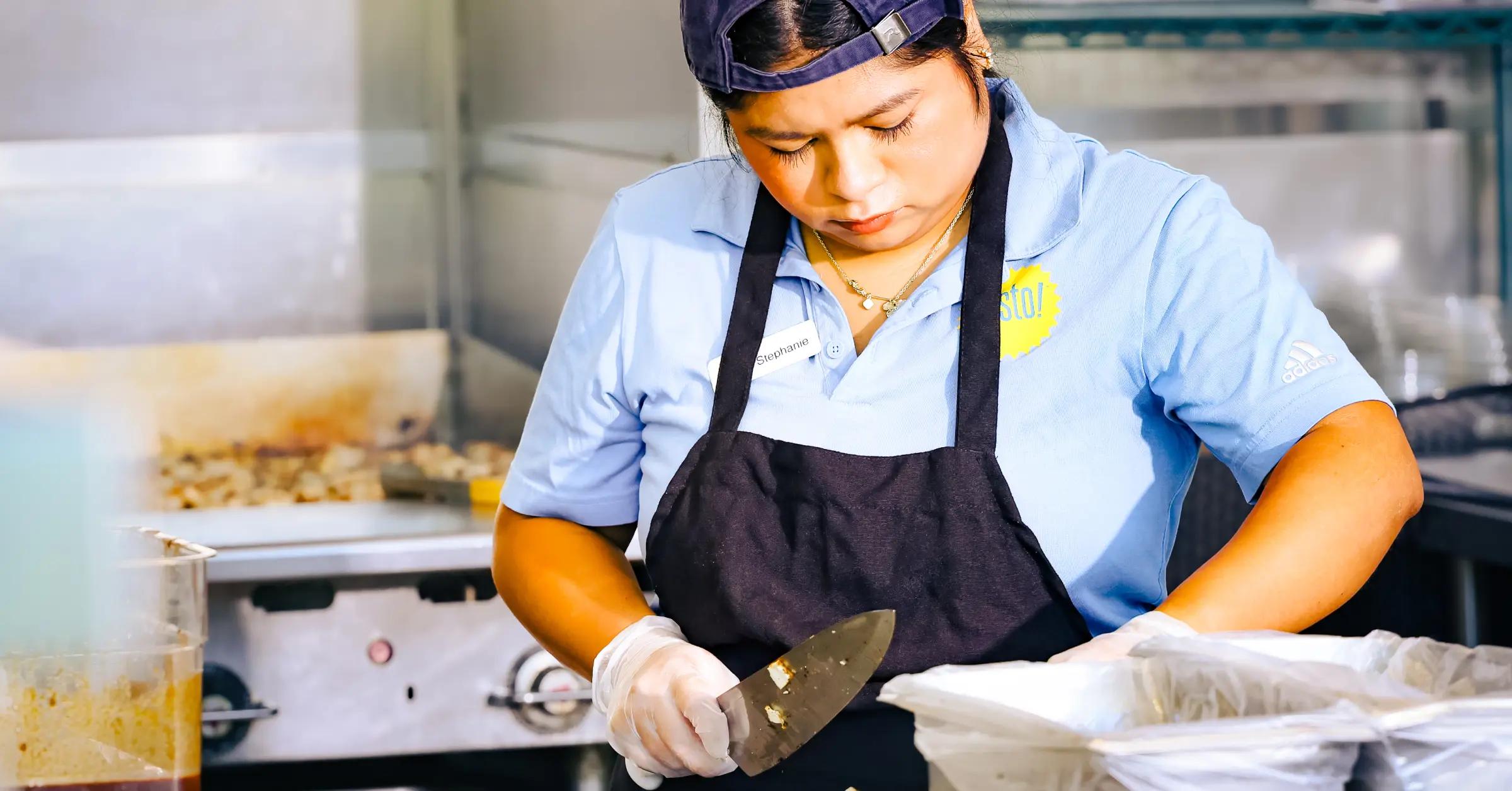 Woman chopping ingredients in restaurant kitchen