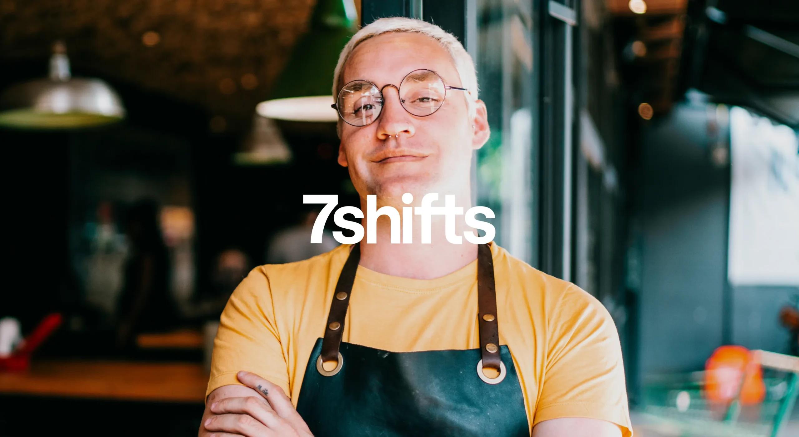 Proud employee wearing apron at restaurant leaning outside front door