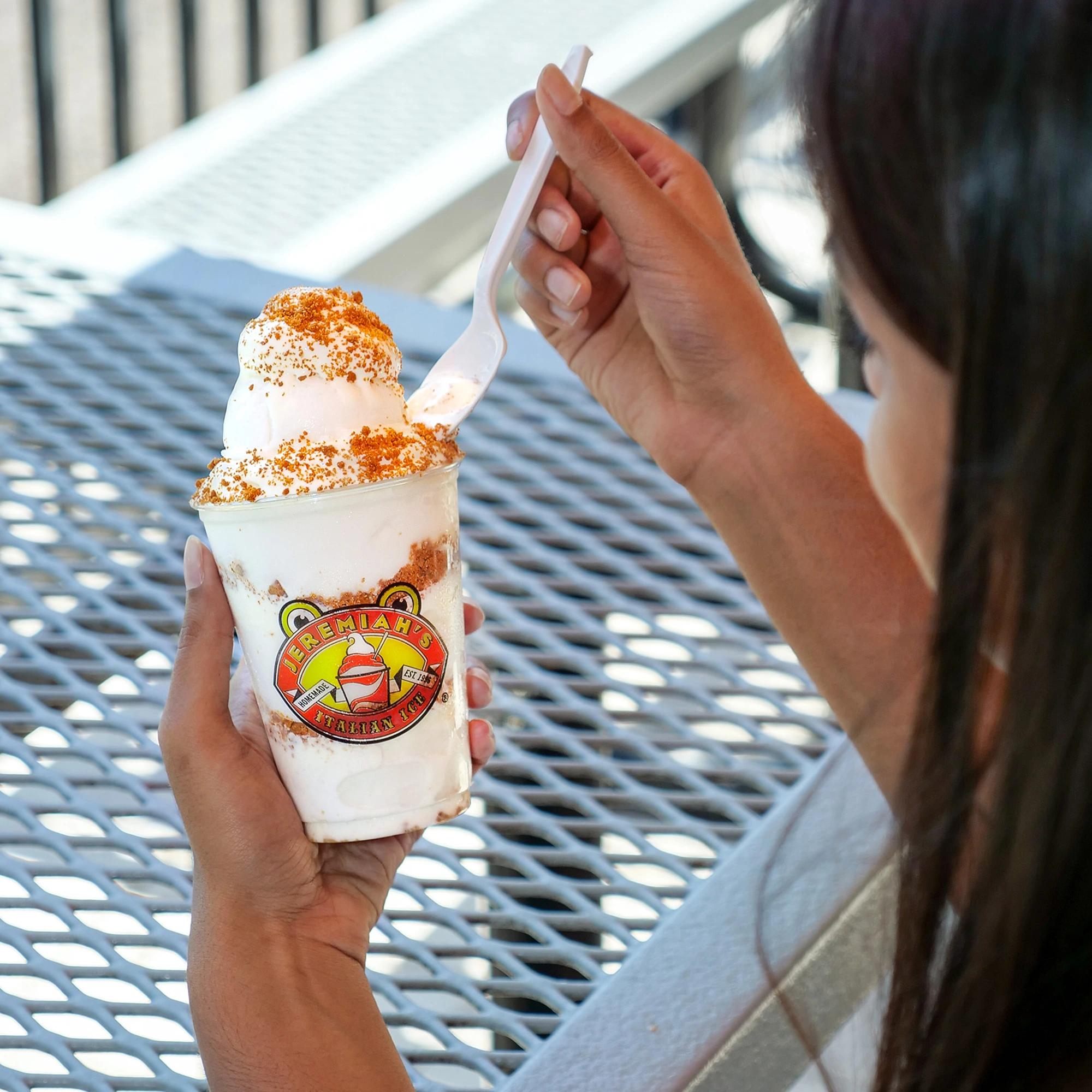 Girl holding ice cream and spoon from Jeremiahs Italian Ice.