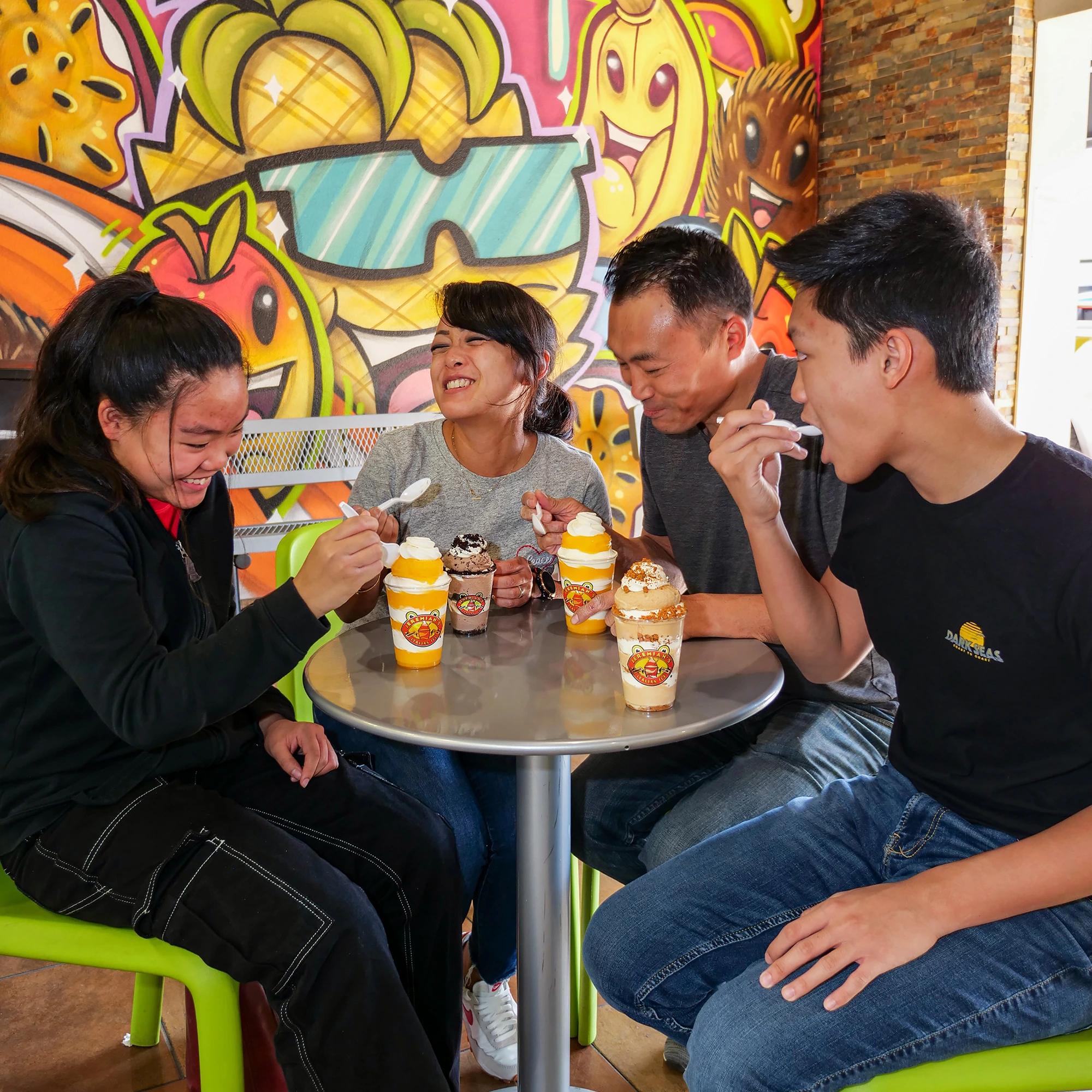 Family of four sitting inside Jeremiah's Italian Ice and eating ice cream/