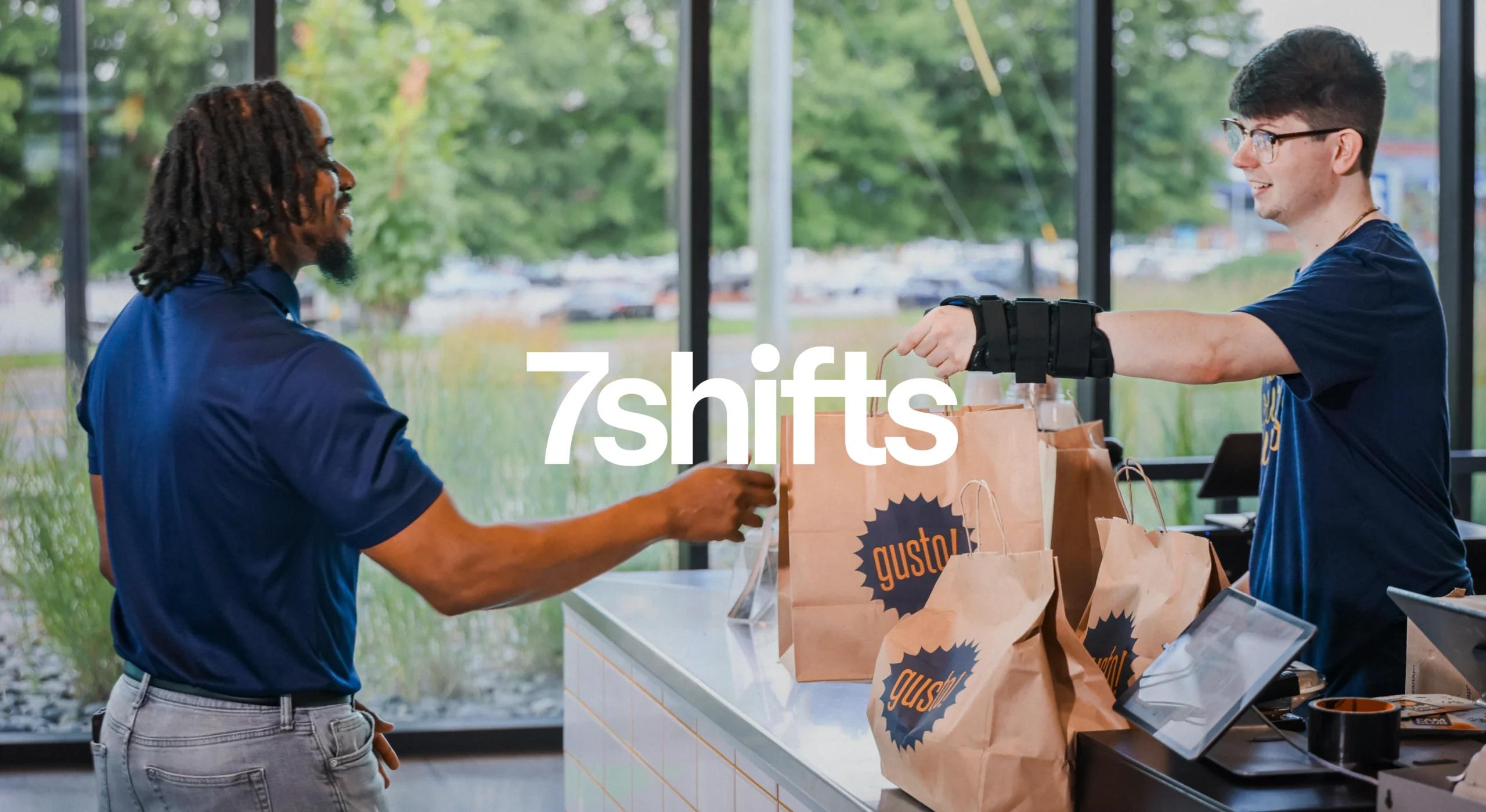 Restaurant worker handing customer a takeout bag.