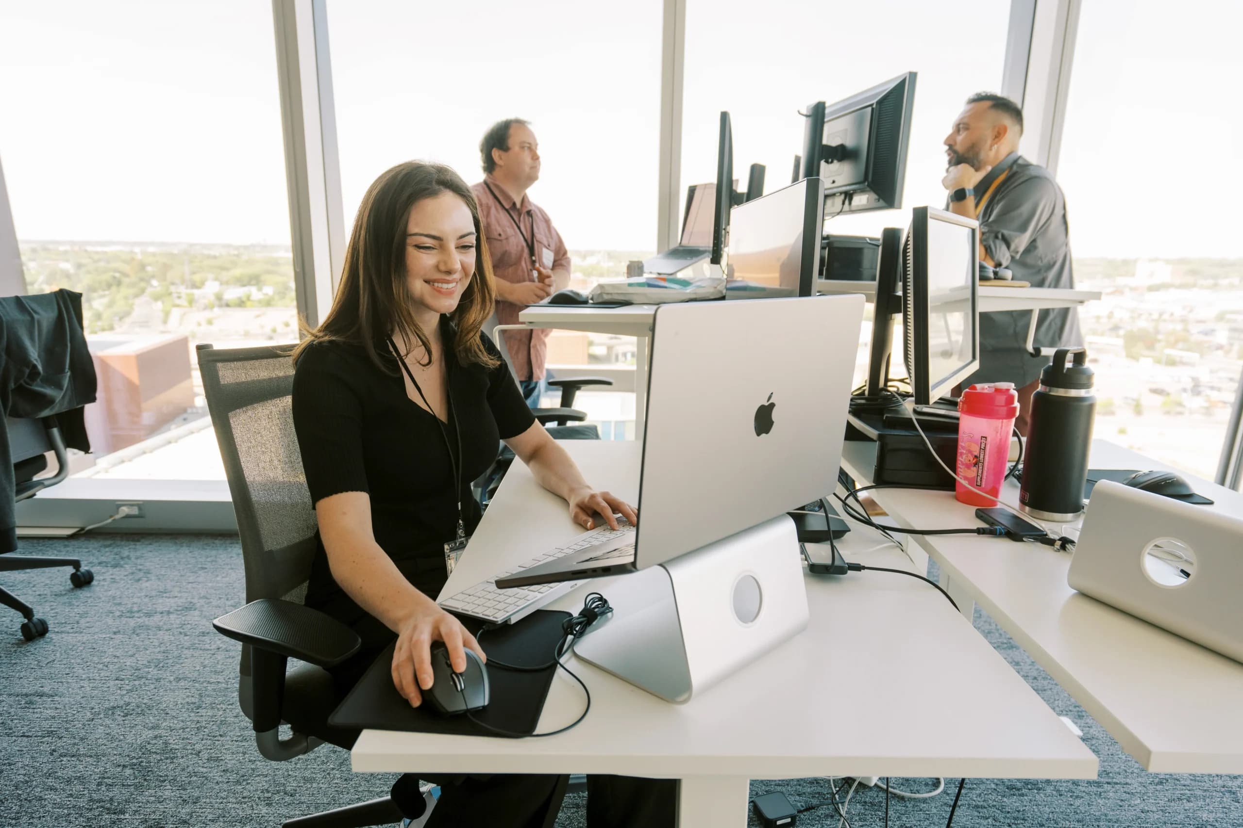 Office workers using computers at modern desks.