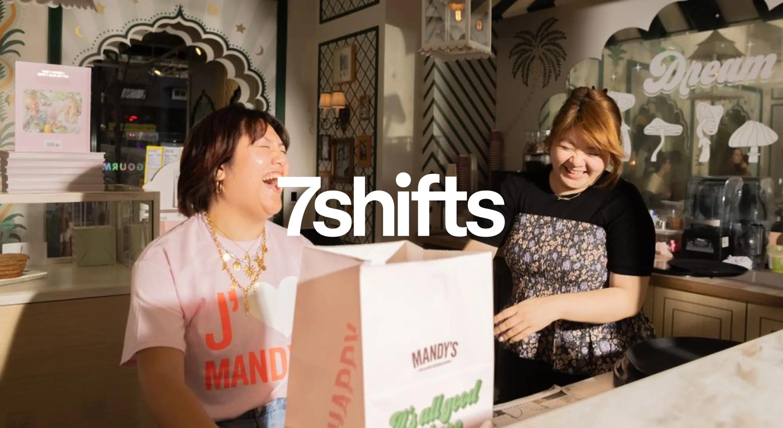 Laughing employees at Mandy's restaurant with white 7shifts logo overlay on top