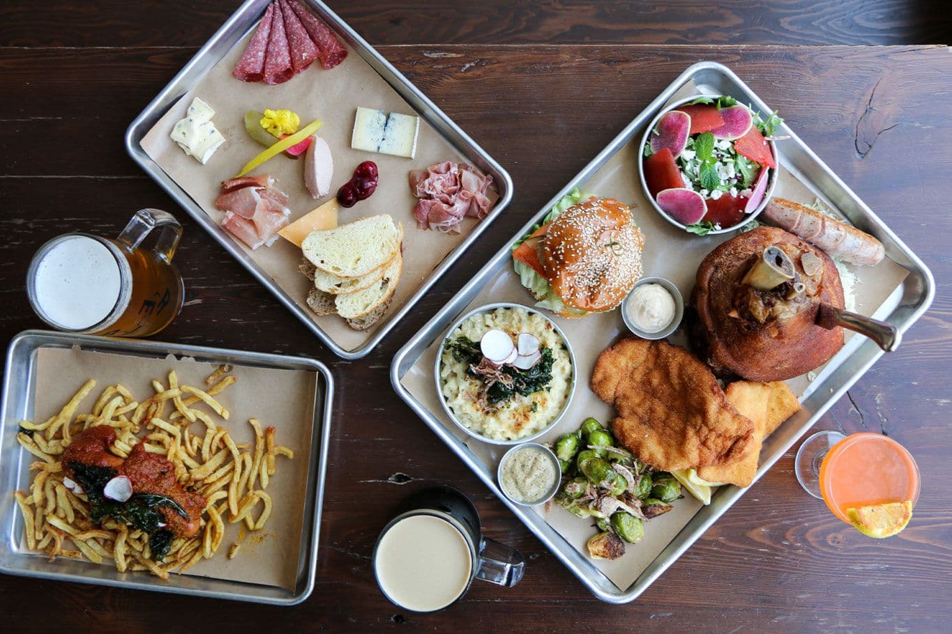 Variety of gourmet dishes on trays with drinks