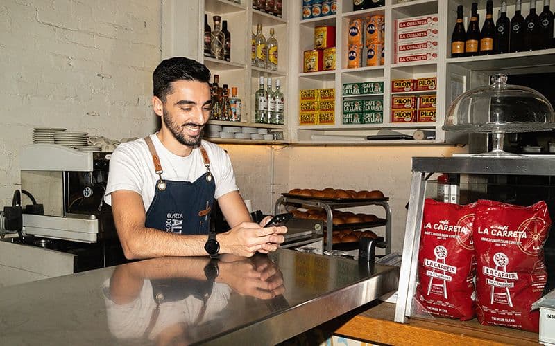 Barista smiling behind coffee shop counter