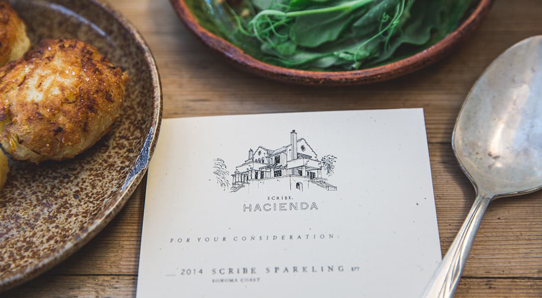 Plate of food next to menu and spoon.